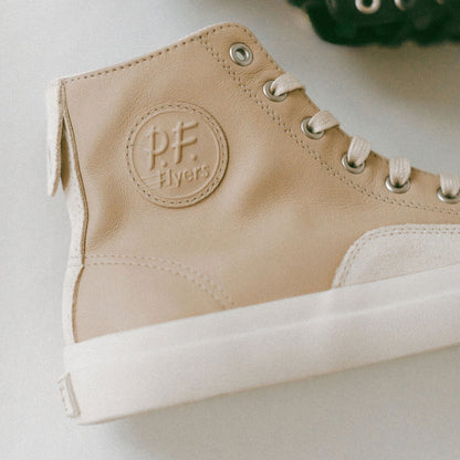 Beige high-top sneaker with a P.F. Flyers brand logo on a light background