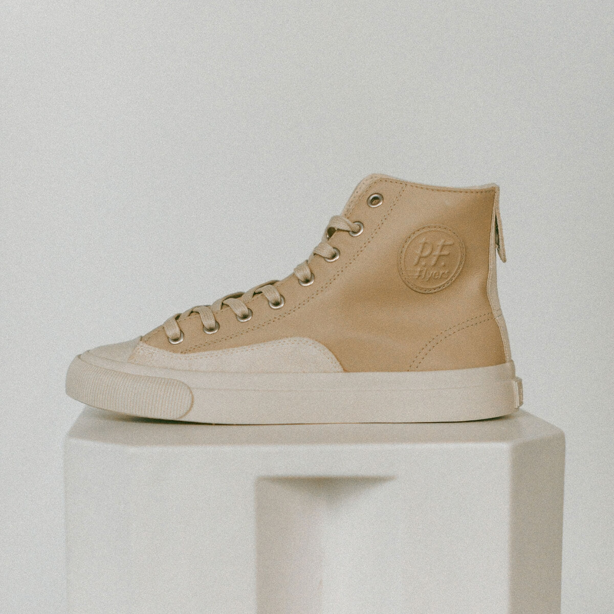 Beige high-top sneaker on a light gray background