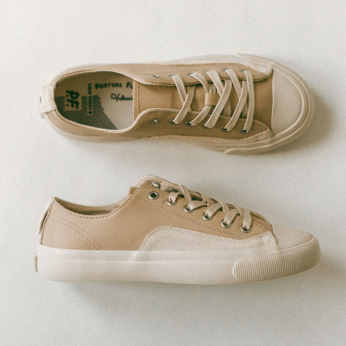 Pair of beige sneakers on a light background
