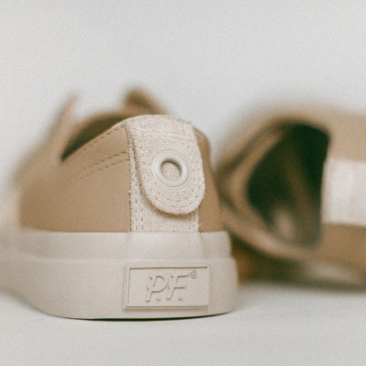 Beige sneaker with P.F. logo on a light background