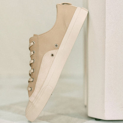 Beige sneaker with white sole on a light gray background