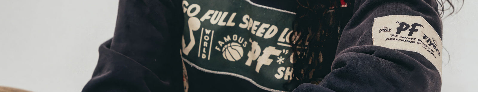 Person wearing a navy hoodie with visible P.F. Flyers branding.