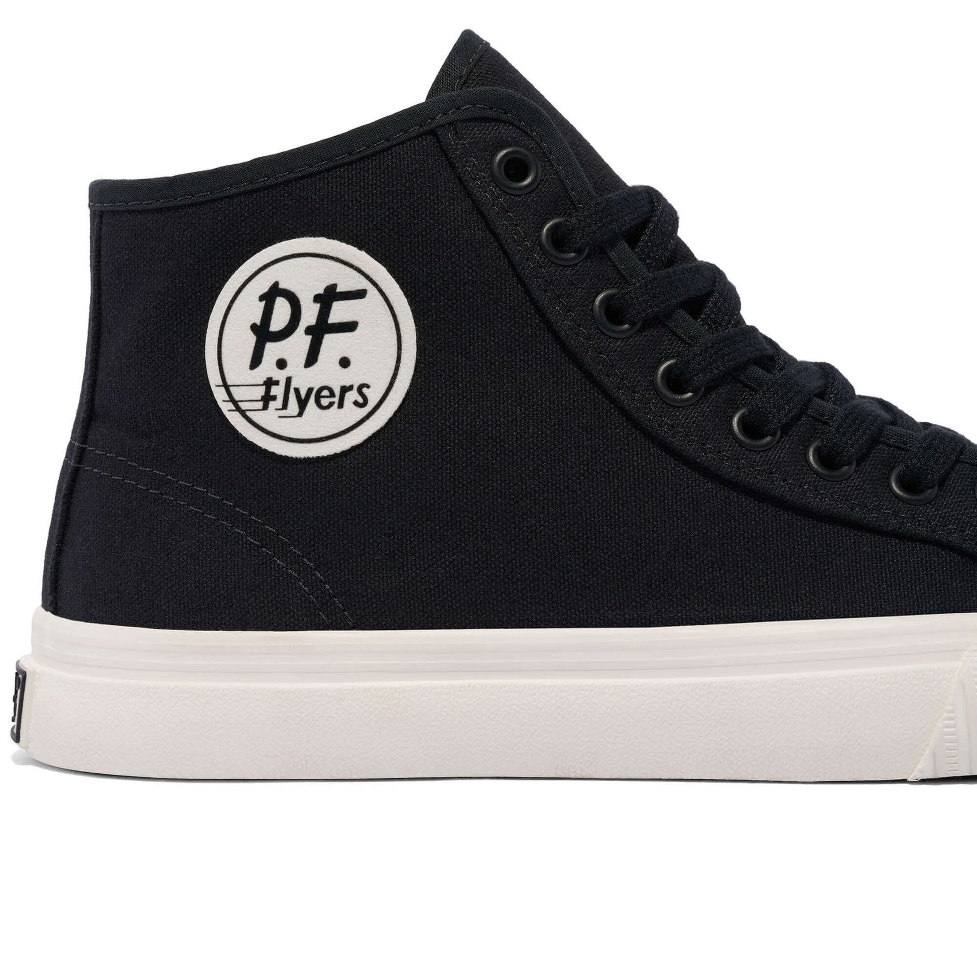 Close-up of a black high-top sneaker with white sole on a white background.