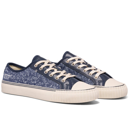 Pair of blue sneakers with white laces on a white background