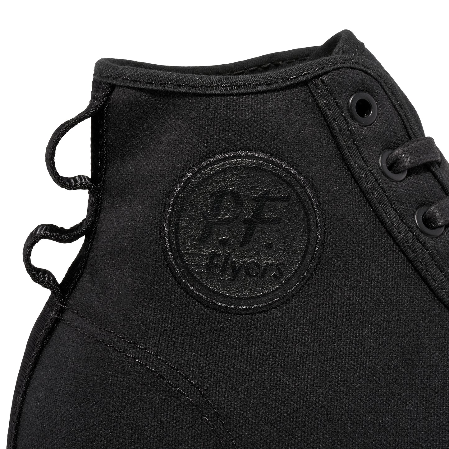 Close-up of a black P.F. Flyers logo on a high-top sneaker against a white background.