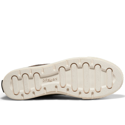 A shoe's off-white rubber outsole set against a plain white background.