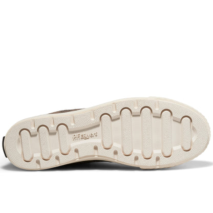 A shoe's off-white rubber outsole set against a plain white background.