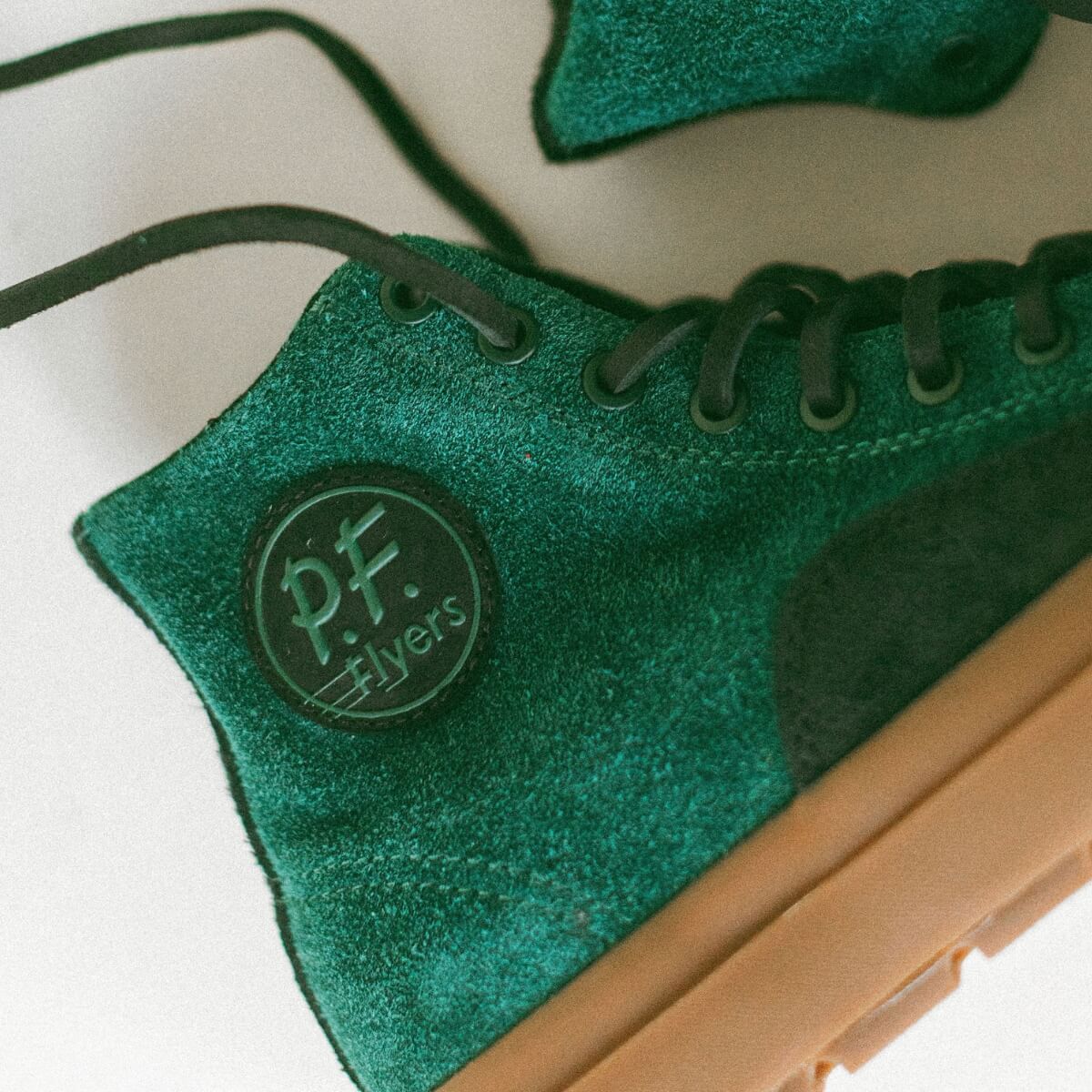 Green suede shoe with 'P.F. Flyers' logo on a white background
