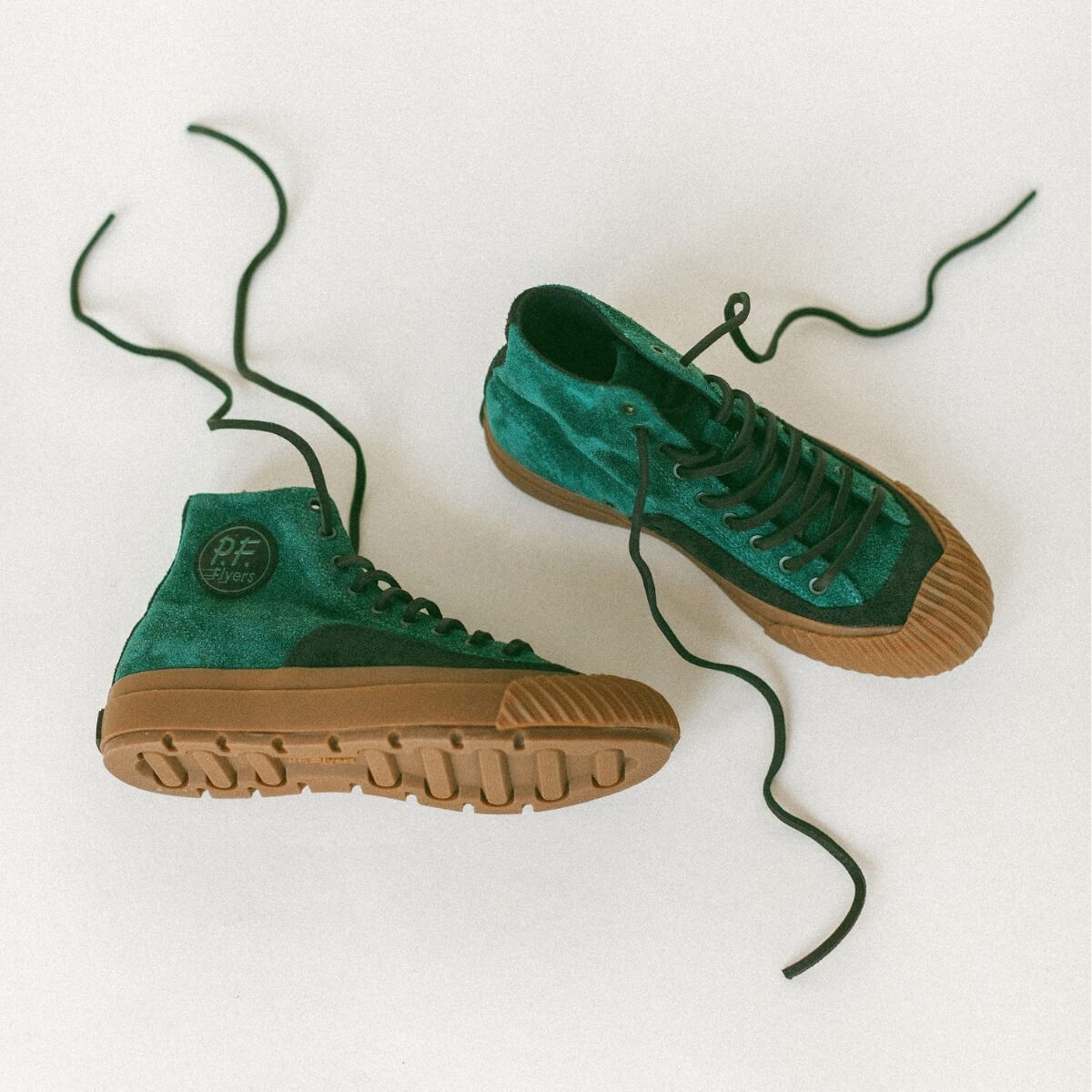 Green high-top sneakers with gum soles on a white background